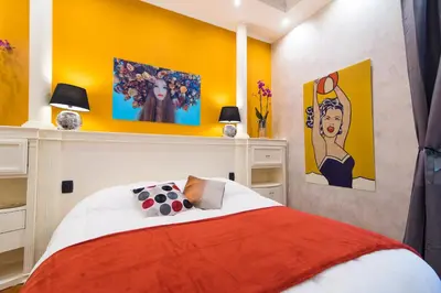 a bedroom with a bed and some paintings on the wall at B&B Arco Di Gallieno in Rome