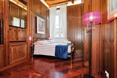 a bedroom with a bed with a pink lamp and a window at Pantheon Family Romantic Suite in Rome