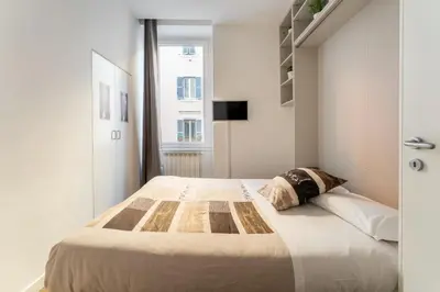 a bedroom with a large bed in a white room at About Colosseo - Appartamento al Colosseo nel cuore di Roma - Free WiFi in Rome
