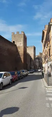 a street with cars parked in front of a castle at Retro Rooms Termini in Rome