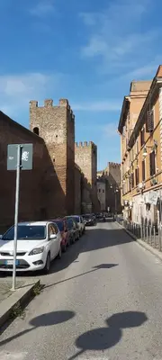 a street with cars parked in front of a castle at Retro Rooms Termini in Rome