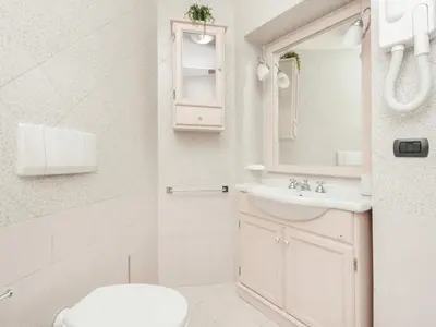 a bathroom with a toilet and a sink and a mirror at Retro Rooms Termini in Rome