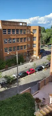 a large building with cars parked in a parking lot at Retro Rooms Termini in Rome