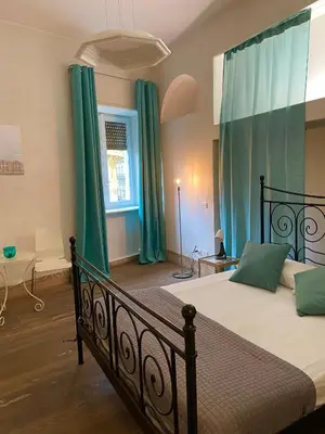 a bedroom with a large bed with green curtains at Spain Apartments in Rome