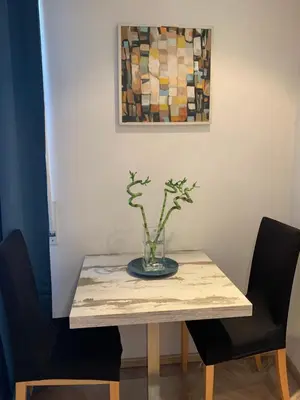 a table with a vase on it with two chairs at Spain Apartments in Rome