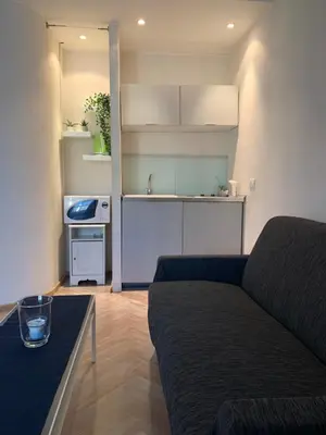 a living room with a couch and a kitchen at Spain Apartments in Rome