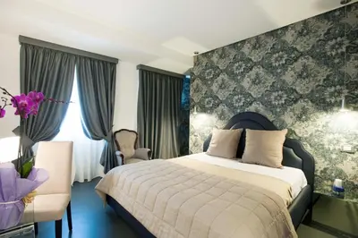 a bedroom with a large bed and a chair at Residenza Monfy in Rome