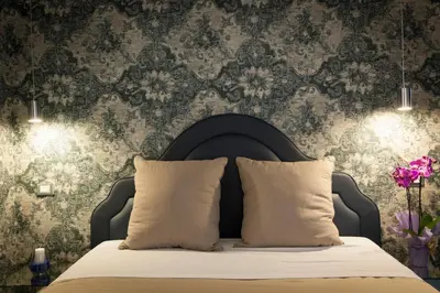 a bedroom with a bed with a damask wallpaper at Residenza Monfy in Rome