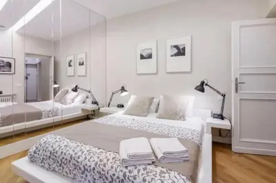 a white bedroom with two beds and a mirror at Campo dei Fiori modern apartment with terrace in Rome