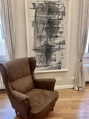 a brown chair in a living room with a painting at Campo dei Fiori modern apartment with terrace in Rome
