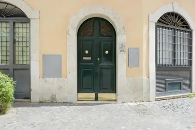 a green door on a building with two windows at Campo dei Fiori modern apartment with terrace in Rome