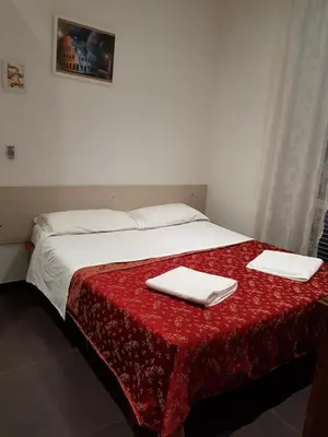 a hallway with a door and a shelf with books at Guest House Hello Roma in Rome