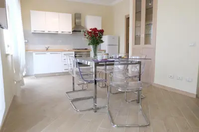 a kitchen with a table with chairs and a vase of flowers at Terrazza sul Parco in Rome