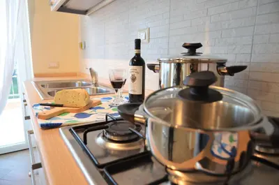 a kitchen counter with a stove with a bottle of wine at Terrazza sul Parco in Rome