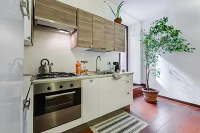 a small kitchen with white cabinets and a tv at Purificazione 44 Guest House in Rome