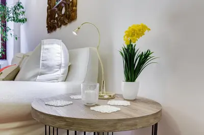 a white couch with an orange pillow and a mirror at Purificazione 44 Guest House in Rome