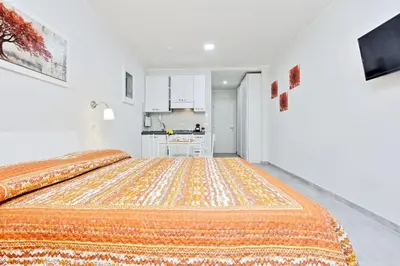 a bedroom with a large bed and a kitchen at Valery Guest House in Rome