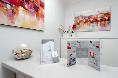 a white counter with paintings and a vase on it at Valery Guest House in Rome