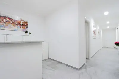 a white hallway with white walls and paintings at Valery Guest House in Rome