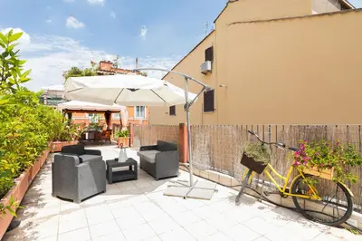 a patio with chairs and an umbrella and a bike at Xystum in Rome