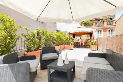 a patio with chairs and tables and an umbrella at Xystum in Rome