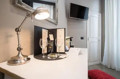 a desk with a lamp and wine glasses on it at Roma 2B in Rome