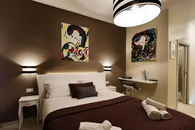 a bedroom with a bed and two paintings on the wall at Guest House Grazioli in Rome