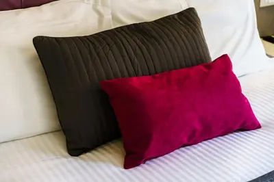 a red pillow sitting next to a black and white bed at Guest House Grazioli in Rome