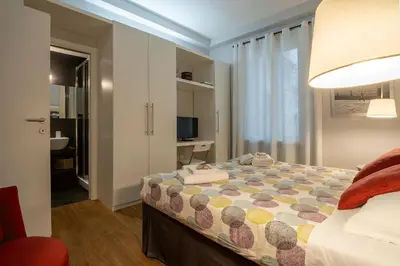 a bedroom with a bed and a room with a television at Fotofever Apt, two bedrooms with air conditioned in elegant shopping area, close to Vatican City in Rome