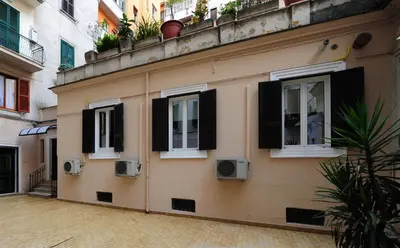 a building with three windows with black shutters at Fotofever Apt, two bedrooms with air conditioned in elegant shopping area, close to Vatican City in Rome