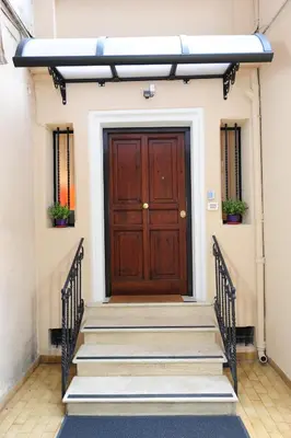 a wooden door with stairs in front of a building at Fotofever Apt, two bedrooms with air conditioned in elegant shopping area, close to Vatican City in Rome