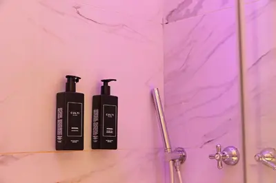 two black shampoo bottles sitting on a shelf in a bathroom at Alla Locanda Malandra in Rome