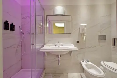 a white bathroom with a sink and a shower at Alla Locanda Malandra in Rome