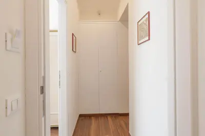 a hallway with white walls and wood floors at Donna Margherita Rome Suite & Rooms in Rome
