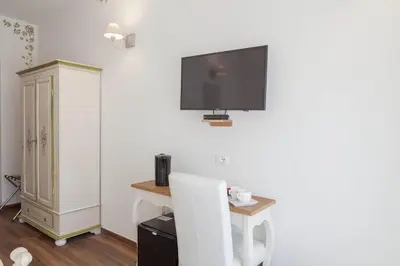 a living room with a tv and a white chair at Donna Margherita Rome Suite & Rooms in Rome