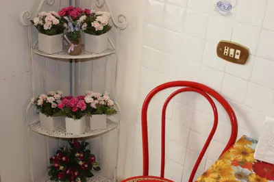 a bathroom with two shelves with flowers and a mirror at Casa Vacanze Voglia di Roma in Rome