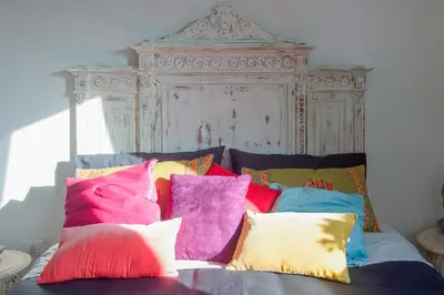 a bed with colorful pillows on top of it at Letto e Latte Roma Guest House in Rome