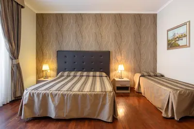 a hotel room with two beds and two lamps at Dreams Roma B&B in Rome
