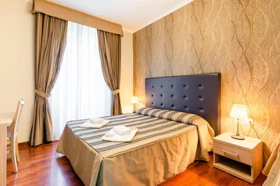 a hotel room with a bed with two towels on it at Dreams Roma B&B in Rome