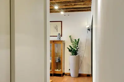 a hallway with a plant in a large white vase at YCH-Farnese Charme in Rome