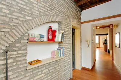 a room with a brick wall with shelves at YCH-Farnese Charme in Rome