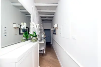 a hallway with white walls and a table with flowers at StarHome Pantheon in Rome