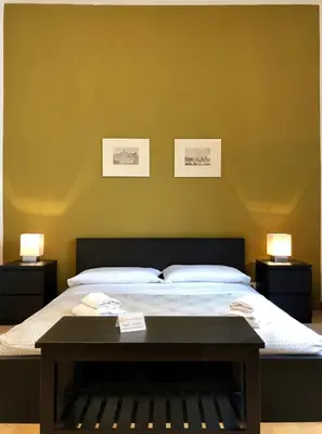 a bedroom with a bed with two lamps and a table at Monti Friendly Rome House in Rome