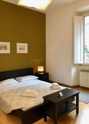 a bedroom with a bed with a table and a window at Monti Friendly Rome House in Rome