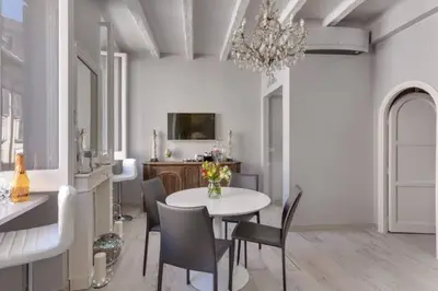 a dining room with a table and chairs and a chandelier at Trevi Luxury Maison in Rome
