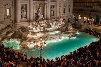 a large group of people standing around a fountain in a building at Trevi Luxury Maison in Rome