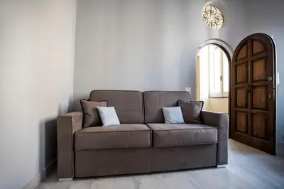 a brown couch with two pillows in a living room at Trevi Luxury Maison in Rome