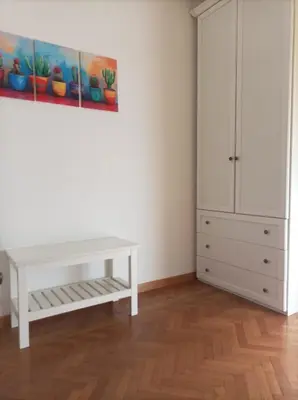 a white room with a white table and a cabinet at La Casa di Emma a Trastevere in Rome