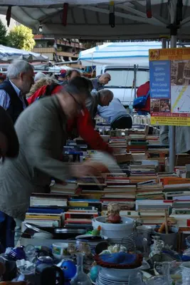 a group of people standing around stacks of books at La Casa di Emma a Trastevere in Rome