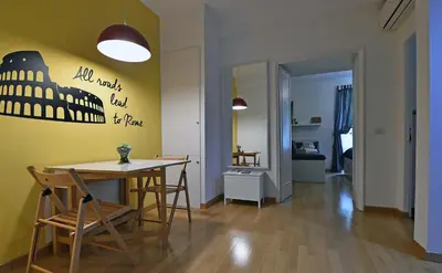a living room with a table and chairs and a yellow wall at Jubilee 2 in Rome